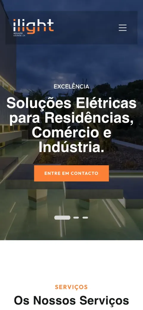 Página inicial da ILIGHT com uma casa moderna iluminada ao anoitecer e o título "Soluções Elétricas para Residências, Comércio e Indústria" (telemóvel)